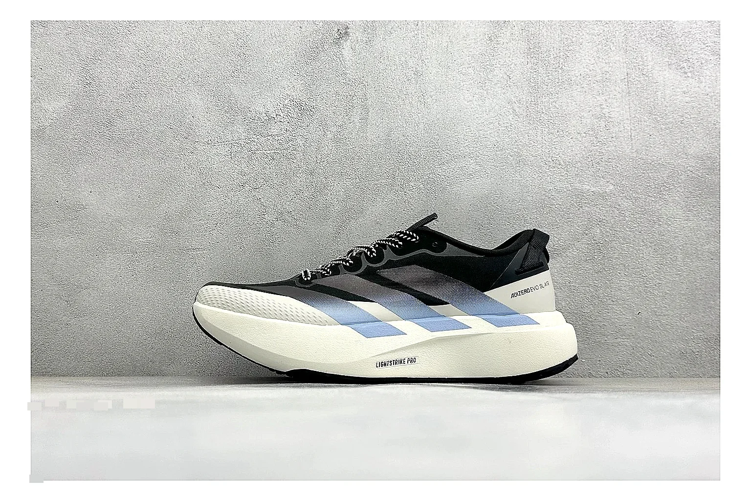 Adidas Adizero Evo Black QC reference photo showing black racing upper, sculpted white sole, Adidas striping, and lightweight performance silhouette