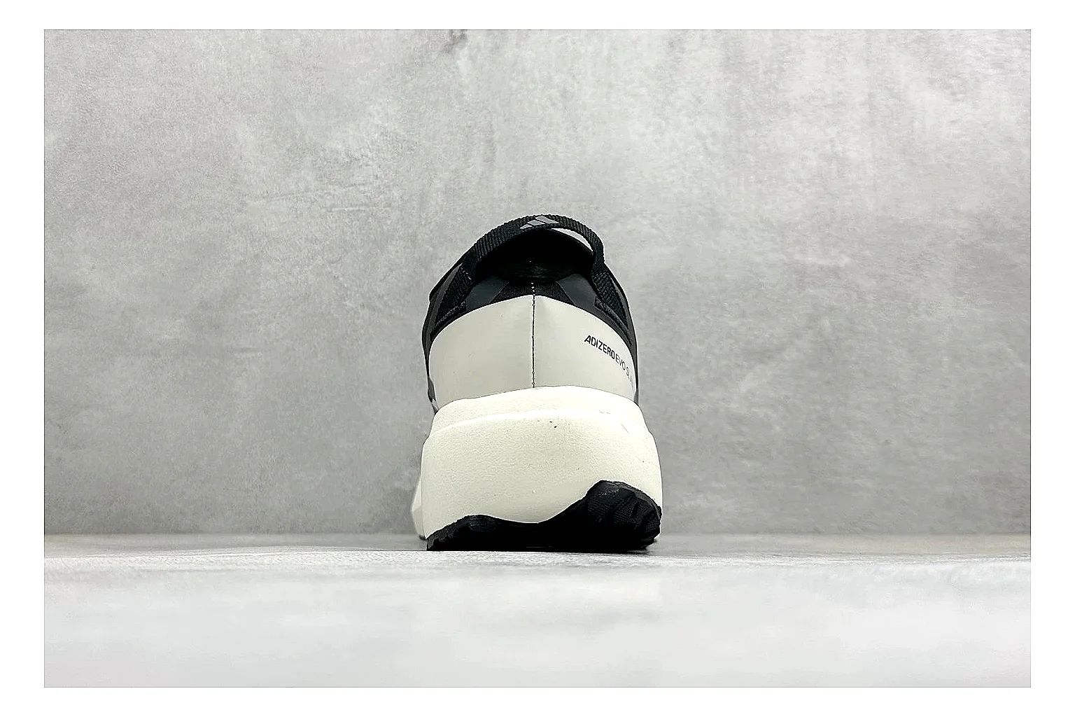 Adidas Adizero Evo Black QC reference photo showing black racing upper, sculpted white sole, Adidas striping, and lightweight performance silhouette