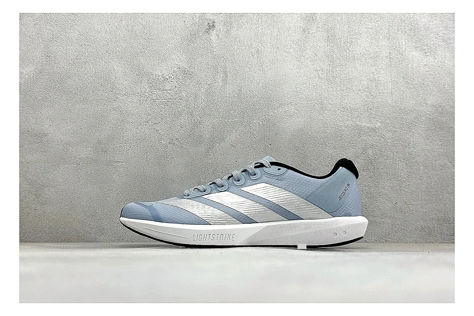 Adidas Adizero Grey Blue QC reference photo showing grey lightweight runner upper, blue Adidas striping, slim racing shape, and low performance sole