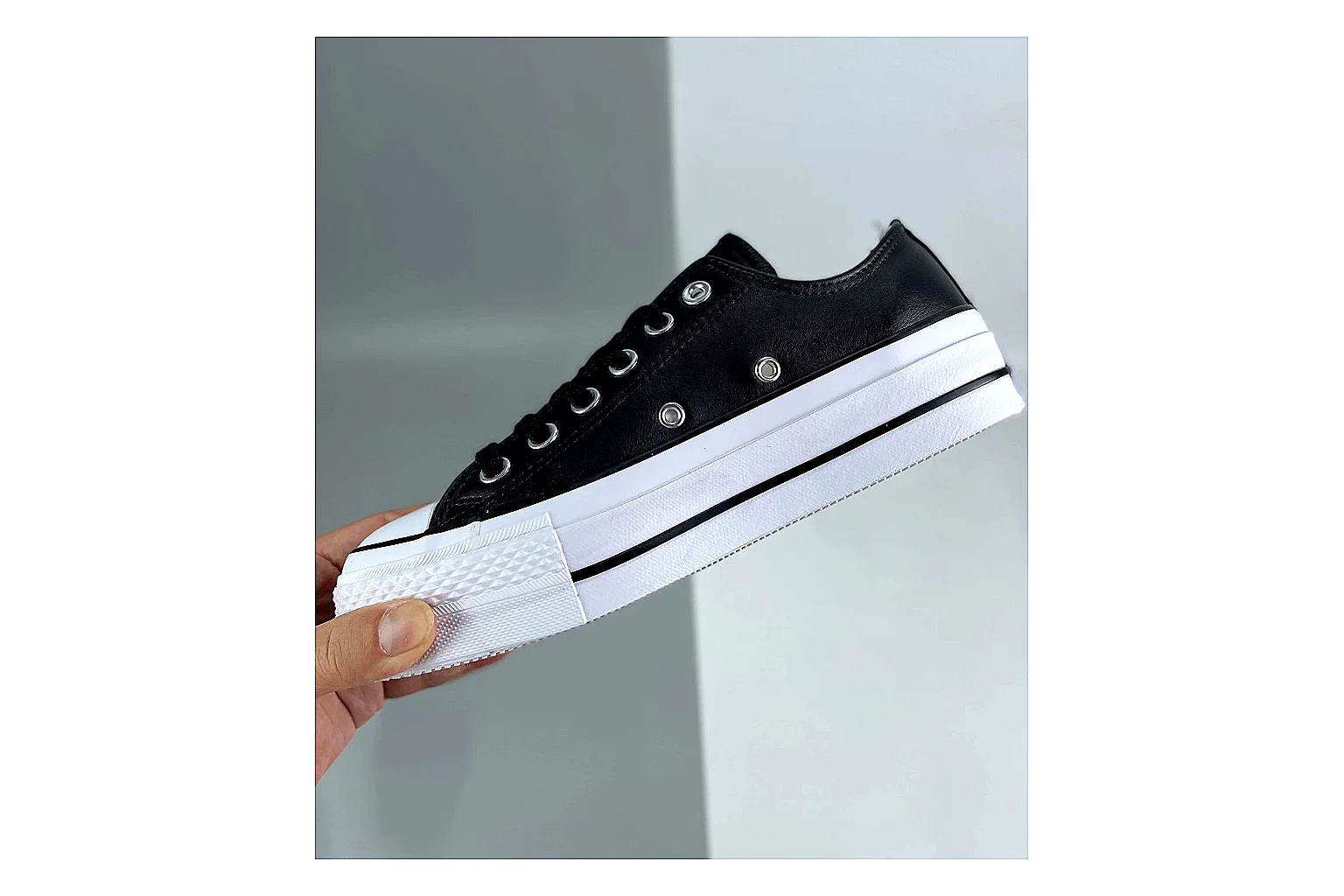 Converse All Star Lift Black Platform Low Top QC reference photo showing black leather low-top upper, silver eyelets, white rubber toe cap, and elevated striped platform sole