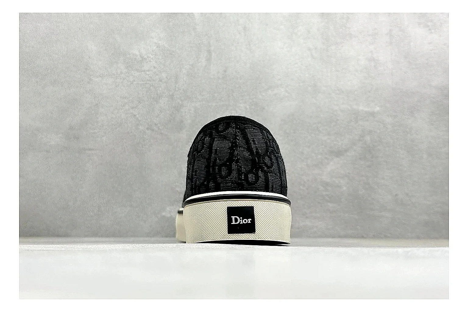 Dior Act Slide Black Low-Top QC reference photo showing black monogram-style upper, low slip-on shape, chunky dark sole, and luxury casual profile