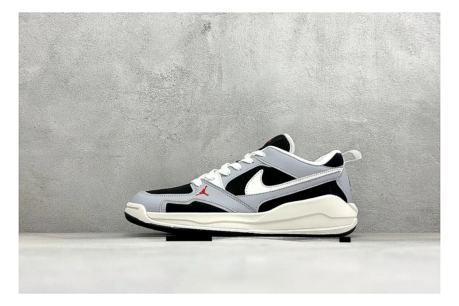 Jordan CMFT Black White QC reference photo showing black and white layered panels, low padded collar, visible Jordan styling cues, and a compact court sole