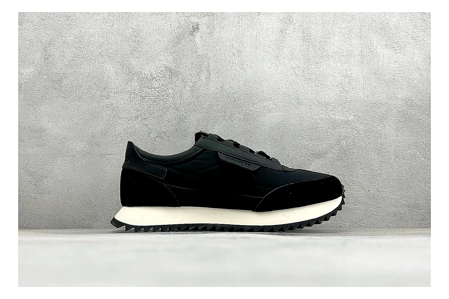Moncler Pacey Black White QC reference image showing black upper, white rugged outsole, low padded collar, and outdoor-leaning tread profile thumbnail 5