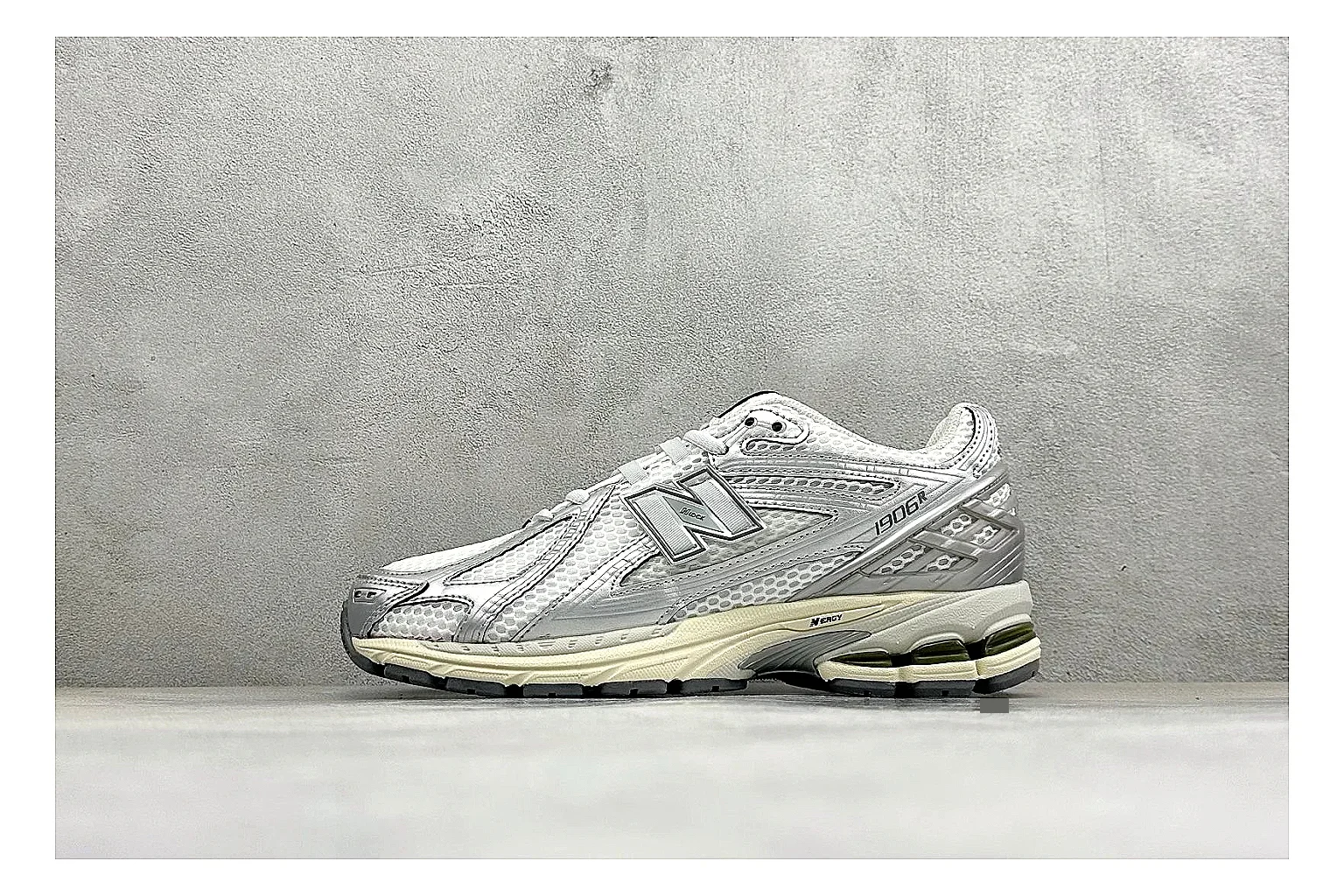 New Balance 1906 Silver Grey QC reference image showing silver overlays, grey mesh panels, technical runner structure, and layered midsole tooling