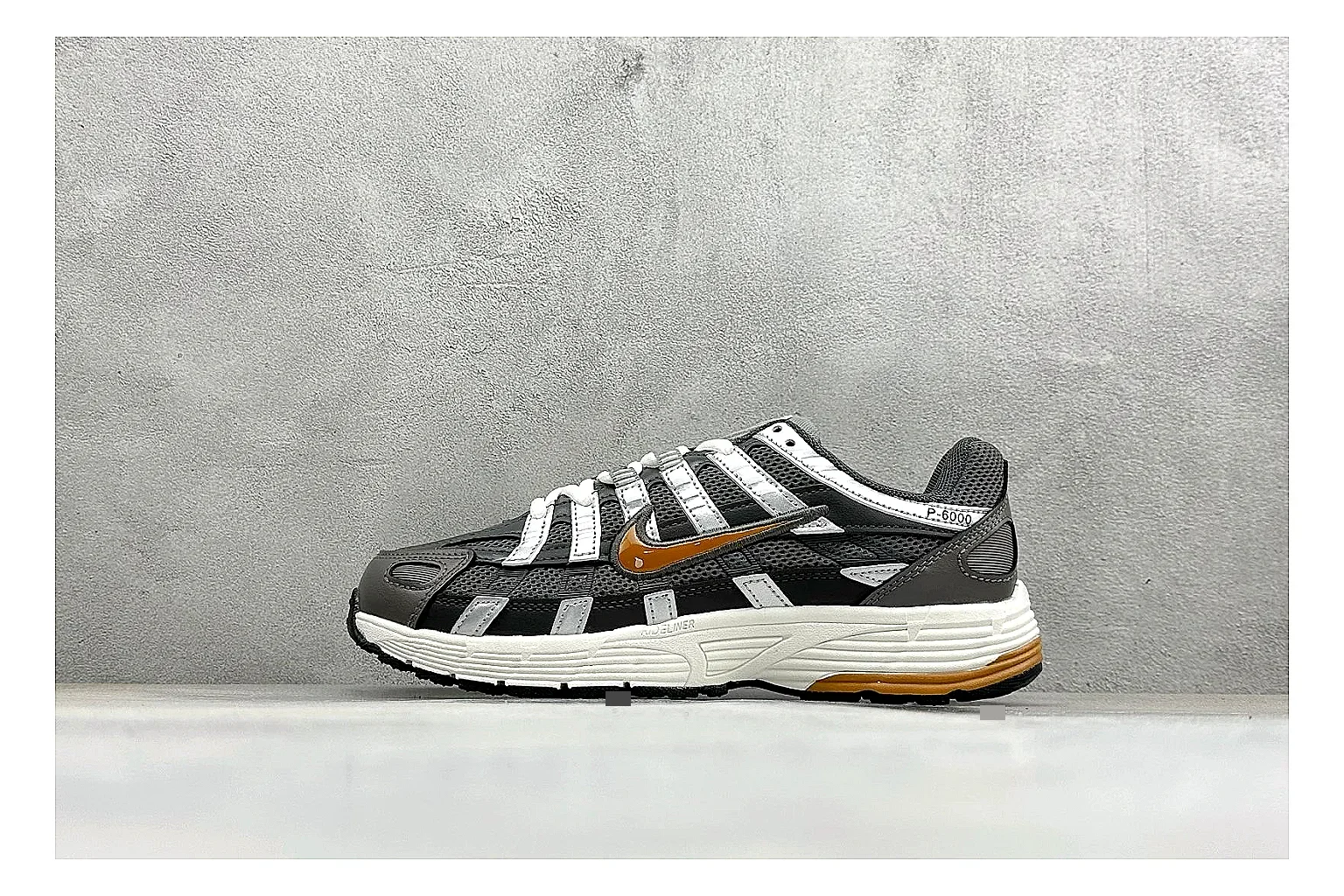Nike P-6000 Black Orange QC reference photo showing black layered runner upper, orange accent hits, retro P-6000 paneling, and cushioned casual sole