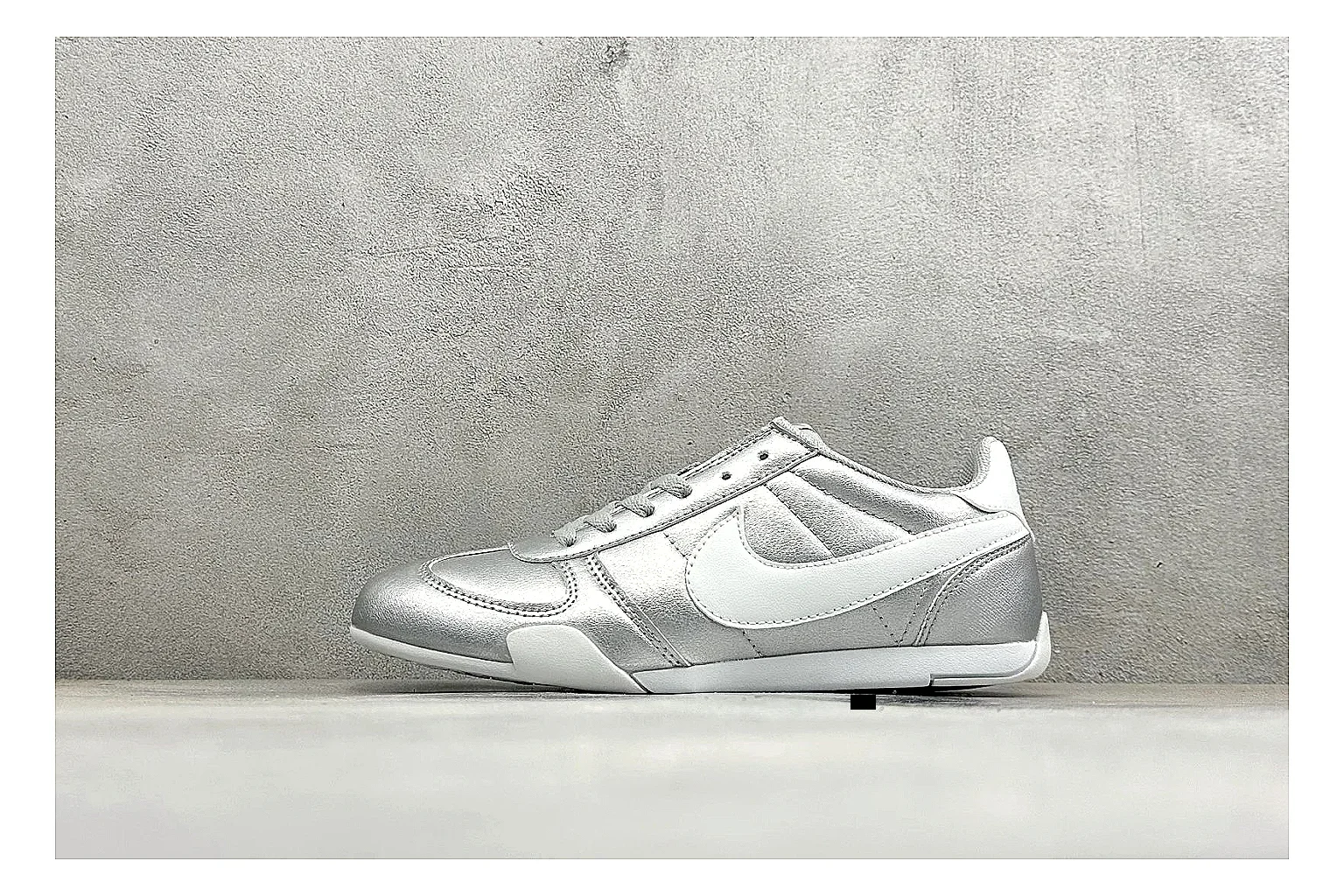 Nike Sprint Sister Silver QC reference photo showing silver retro-runner upper, slim low-top shape, layered side panels, and a light everyday sole