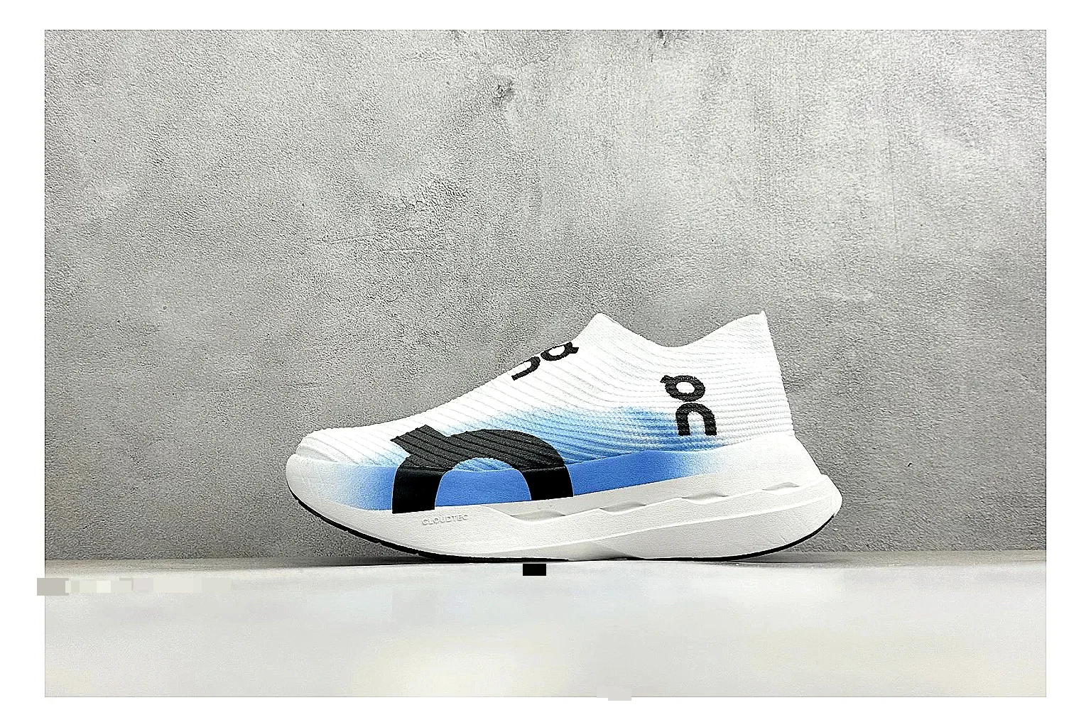 On Cloudboom White Blue QC reference photo showing white performance mesh, blue gradient accents, slim racing profile, and segmented CloudTec sole