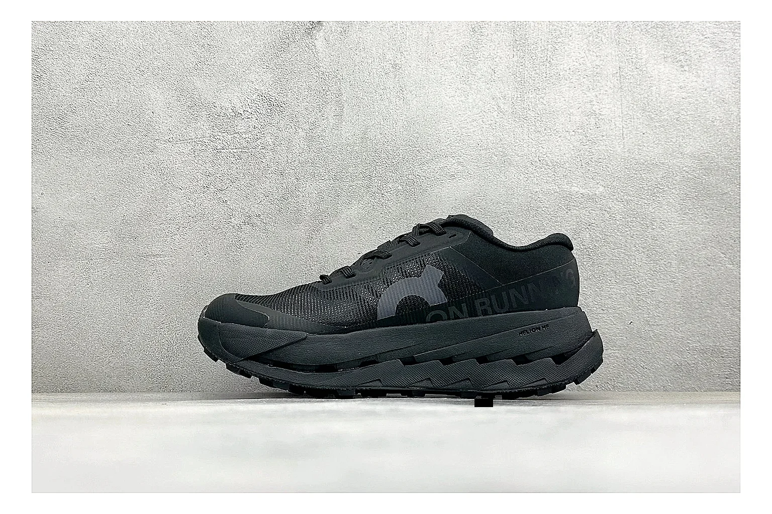 On Cloudmonster Triple Black QC reference photo showing triple black running upper, oversized CloudTec pod sole, tonal laces, and rounded performance shape