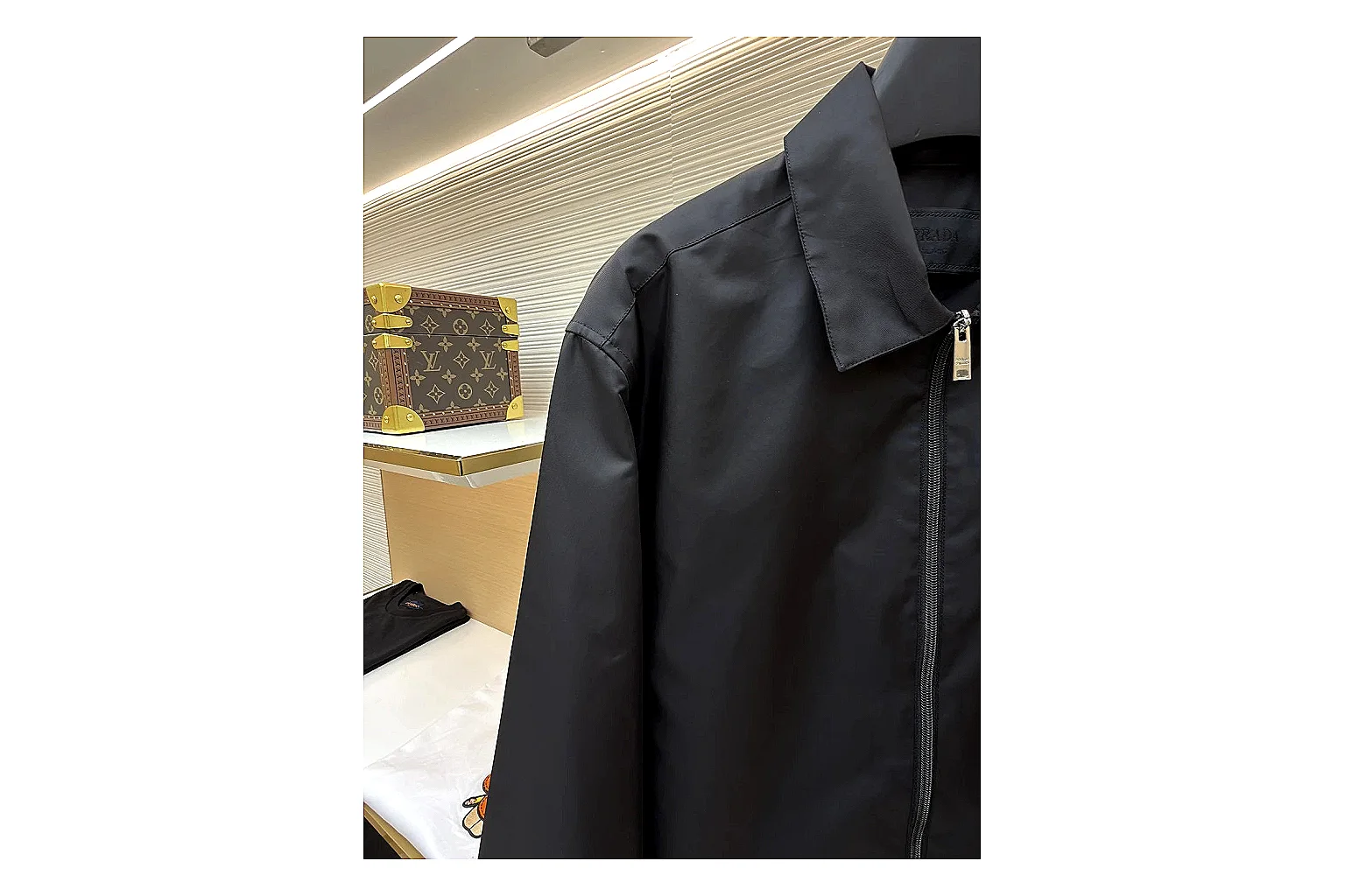 Prada Re-Nylon Hooded Jacket Black Jacket QC photo reference showing black Re-Nylon hooded jacket with recycled-nylon texture, hood structure, zipper line, sleeve cuffs, and light shell shape