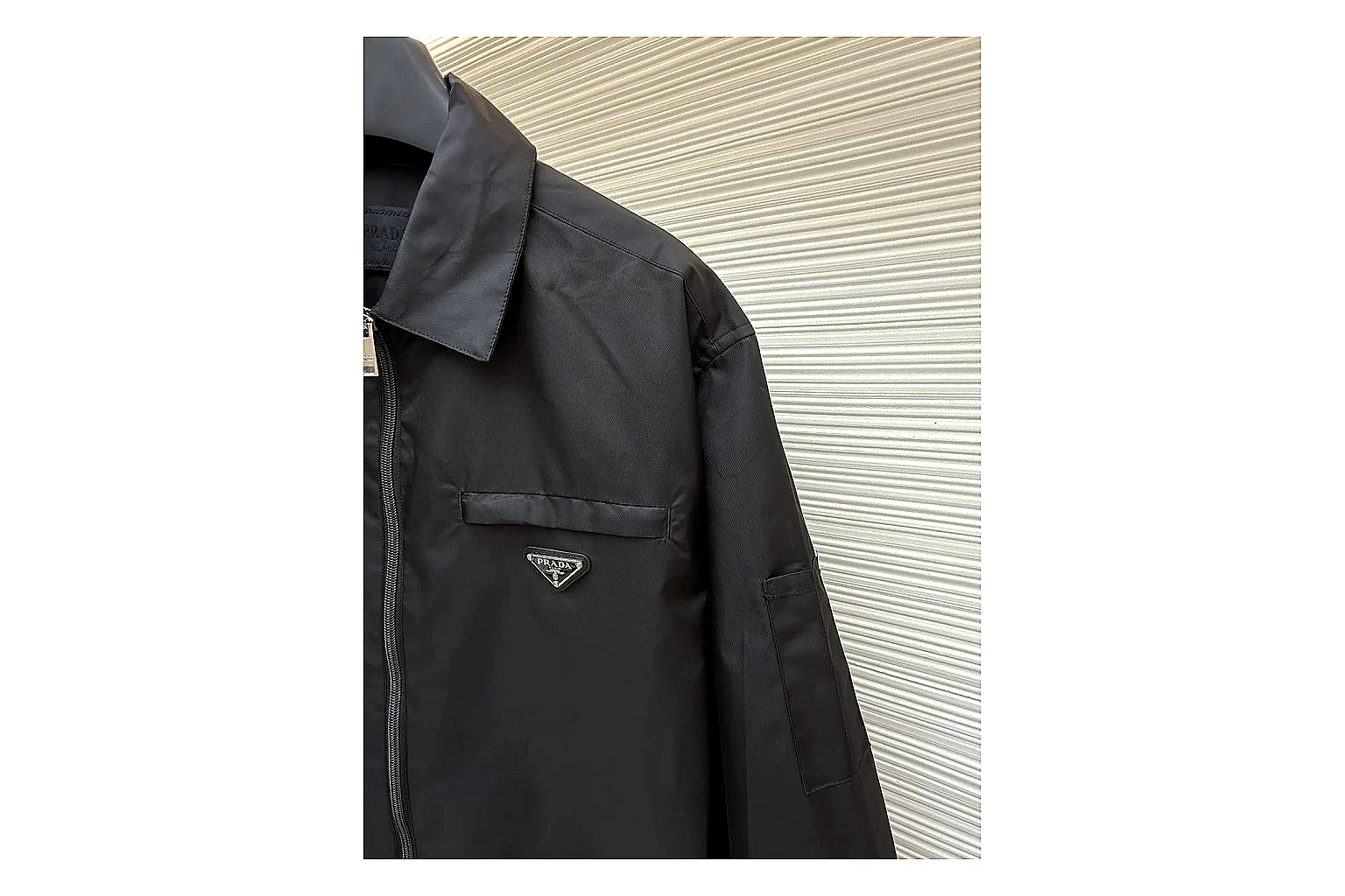Prada Re-Nylon Hooded Jacket Black Jacket QC photo reference showing black Re-Nylon hooded jacket with recycled-nylon texture, hood structure, zipper line, sleeve cuffs, and light shell shape thumbnail 4