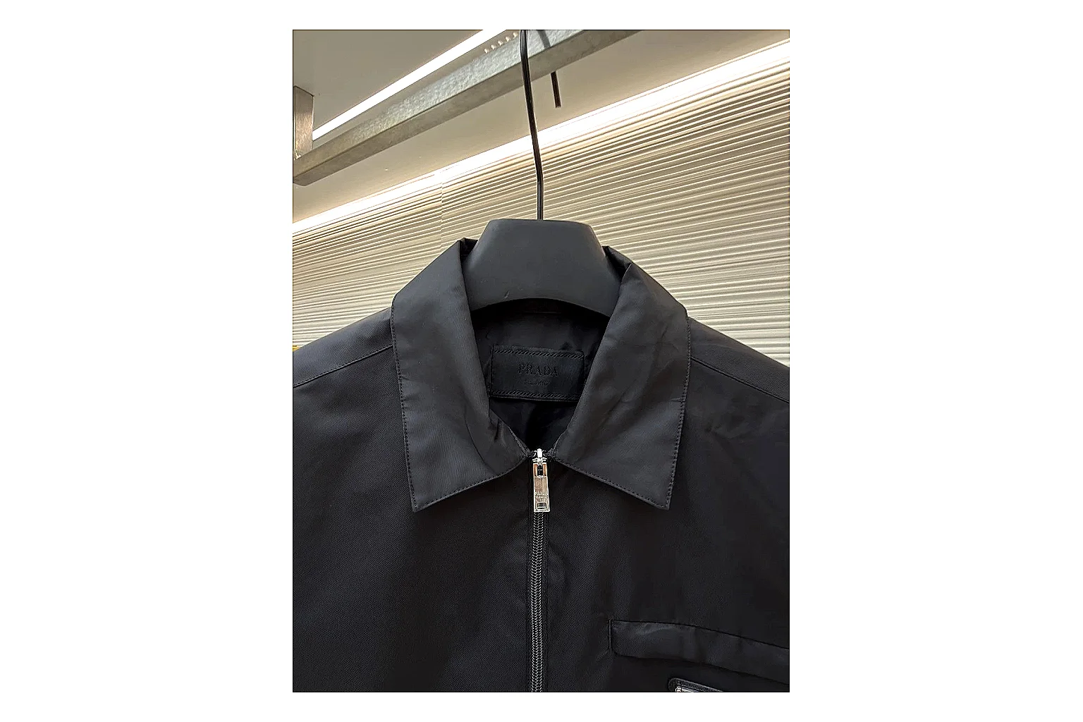 Prada Re-Nylon Hooded Jacket Black Jacket QC photo reference showing black Re-Nylon hooded jacket with recycled-nylon texture, hood structure, zipper line, sleeve cuffs, and light shell shape thumbnail 5