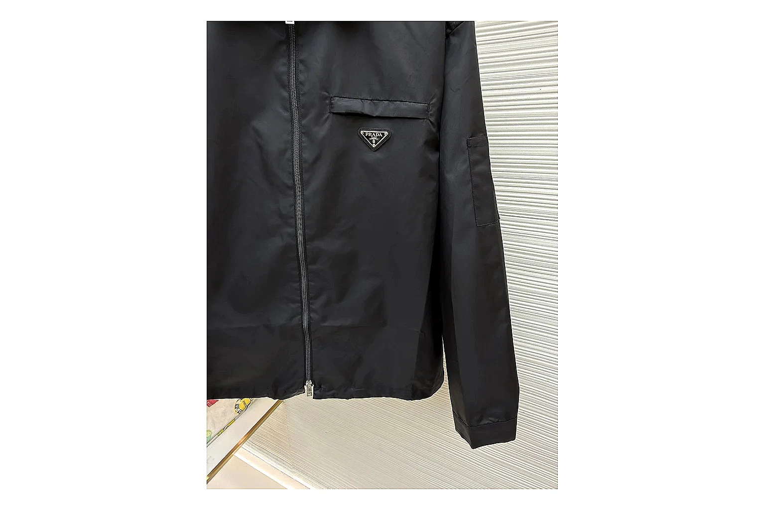 Prada Re-Nylon Hooded Jacket Black Jacket QC photo reference showing black Re-Nylon hooded jacket with recycled-nylon texture, hood structure, zipper line, sleeve cuffs, and light shell shape thumbnail 6